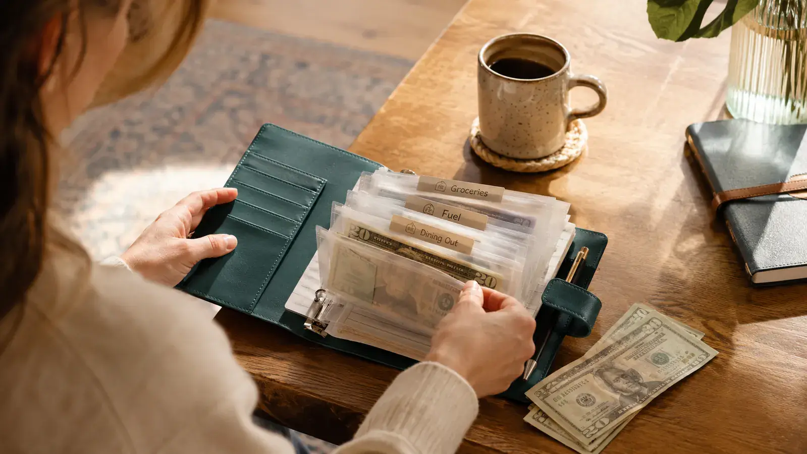 SKYDUE Budget Binder open on a kitchen table with labeled cash envelopes spread out alongside a monthly budget worksheet